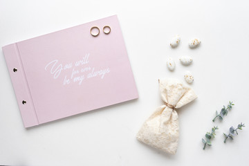 Wedding wish book, cany, weddings rings and oregano branches. Top view.