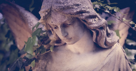 Close up of an ancient statue of guardian angel (vintage style photo)