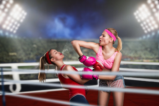 Two female kickboxers fights on the ring