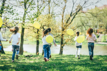Obraz premium Children with yellow balloons playing together