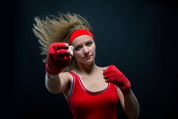 Female boxer in red boxing bandages and sportswear