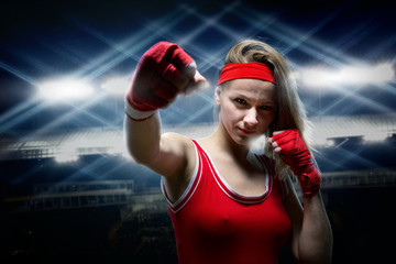 Female kickboxer in boxing bandages makes punch