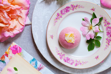Pink tones flatlay with roses, raspberry cake and tea