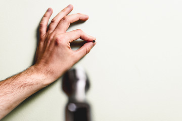 Hammering a nail into the wall. Concept of renovation, housework. The man is holding a blue hammer in his hand, holding a nail in the other hand. Handyman, DIY.