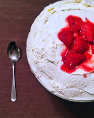 Berry trifle with spoon alongside, seen from above and sitting on table.