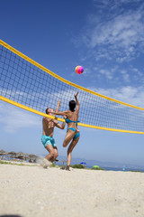 Woman and man fit, strong, healthy, doing sport on beach. Beach volleyball concept. Couple have fun playing volleyball. Young sporty active couple beat off volley ball, play game on summer day.