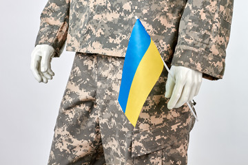 Fototapeta premium Mannequin holds ukrainian flag. White isolated background.