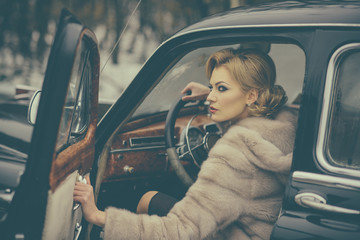 sexy woman in fur coat. Call girl in vintage car. Travel and business trip or hitch hiking. Retro collection car and auto repair by driver. Escort and security guard for luxury woman