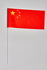 Flag of China with flag pole over white background. Close up. Isolated chinese flag symbol.