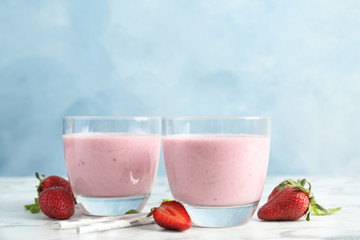 Glasses with healthy detox smoothie and strawberries on table