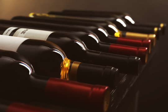 Naklejka Bottles with delicious wine on shelf, closeup. Professional sommelier