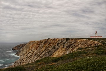 Fototapeta na wymiar Views of the wild Atlantic Ocean with beautiful cliffs in Cape Espichel