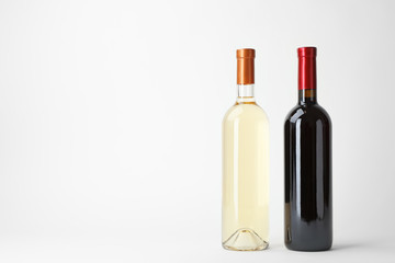 Naklejka premium Bottles of expensive red and white wines on light background