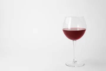 Fotobehang Glass of expensive red wine on light background © New Africa