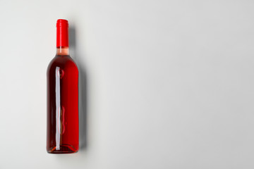 Bottle of expensive rose wine on light background, top view