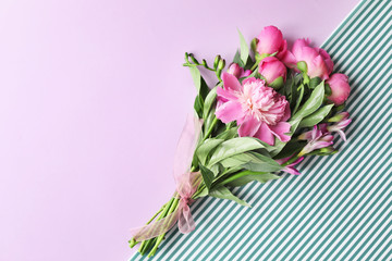 Bouquet of beautiful peony flowers on color background, top view
