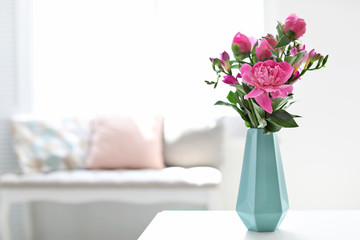 Vase with beautiful peony flowers on table indoors