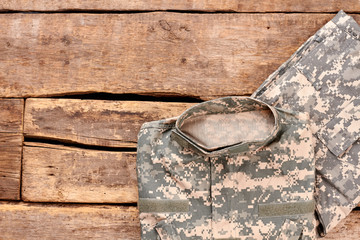 Military clothes on wood. Flat lay, top view. Wooden desk surface background.