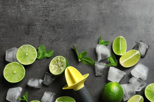 Flat lay composition with lime, mint and juicer on grey background. Refreshing beverage ingredients