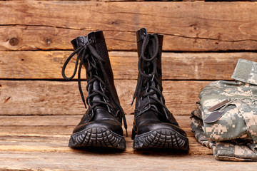 Pair of military boots. Set of soldiers outfit on wood.
