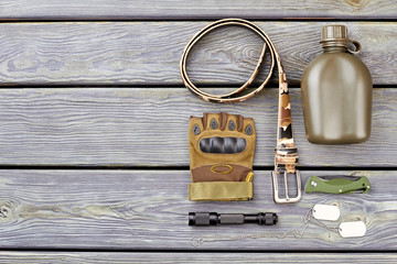 Flat Lay of army soldier necessities. camp combat accessoires on wood.