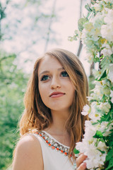 Very beautiful woman in nature surrounded by real flowers.