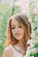 Very beautiful woman in nature surrounded by real flowers.