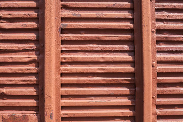 Old red background. The texture of the train car. Stamped metal surface is brown color.