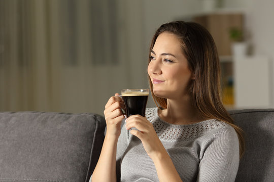 Satisfied woman enjoying coffee in the night