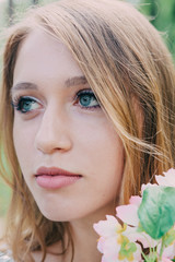 Very beautiful woman in nature surrounded by real flowers.