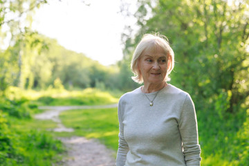 Happy elderly woman in a sunny park