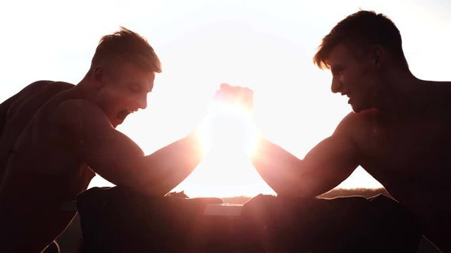 Two armwrestlers, have an arm wrestling match
