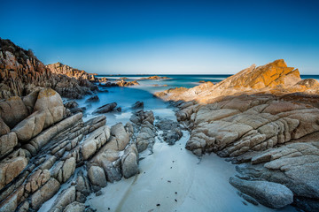 Long exposure of the surf and rocks at the Bay of Fires in Tasmania, Australia - obrazy, fototapety, plakaty