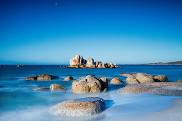 Bay of Fires rock formation during a long exposure, with the moon rising in the background