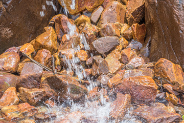 Small waterfall among rocks and stones in moss