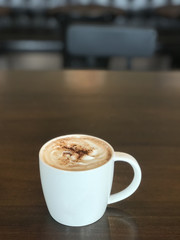 A cup of coffee on wooden table in coffee shop. Coffee and drink concept