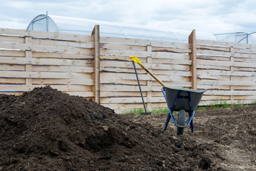 Garden wheelbarrow, shovel and humus.