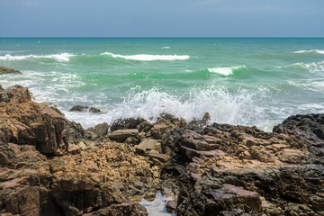 Fototapeta na wymiar Rocks by the beach with waves splahes
