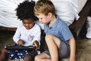 Friends playing with tablet in bedroom