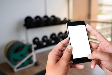 Young man Hand holding smartphone in gym to  fitness phone fitness exercise concept