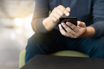 man using smart phone on and  reading message in coffee shop