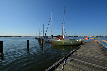 Fototapeta na wymiar Segelboote im Hafen Altefähr mit Blick zur Rügenbrüke und Skyline von Stralsund