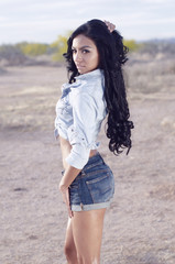 Beautiful woman wearing denim shorts and top outdoors in desert location