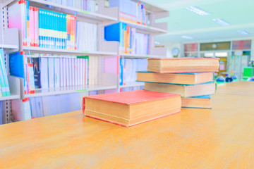 old book red - green. heap are interior library school on wooden table and blurry bookshelves background. education learning concept with copy space add text