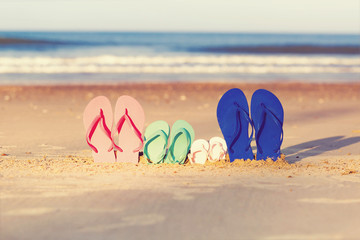 Fototapeta na wymiar Colorful sandals on the sand at the beach