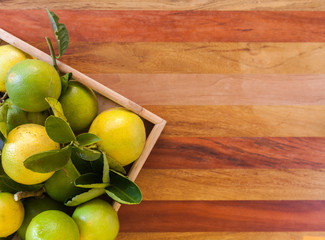 Key lime or Mexican lime in a wooden box on floor, one of main ingredient thai food and traditional...