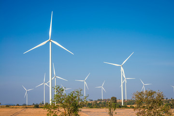 Fototapeta premium Wind turbines generating electricity on mountain with blue sky