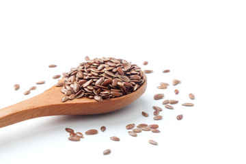 Flax seeds in a wooden spoon on white background