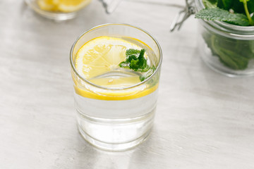 Detox water fitness healthy nutrition diet concept Fresh lemon mint detox drink glass white wooden table close up