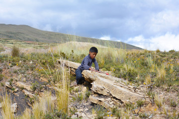 Naklejka premium Little native american boy in the countryside of Andes.